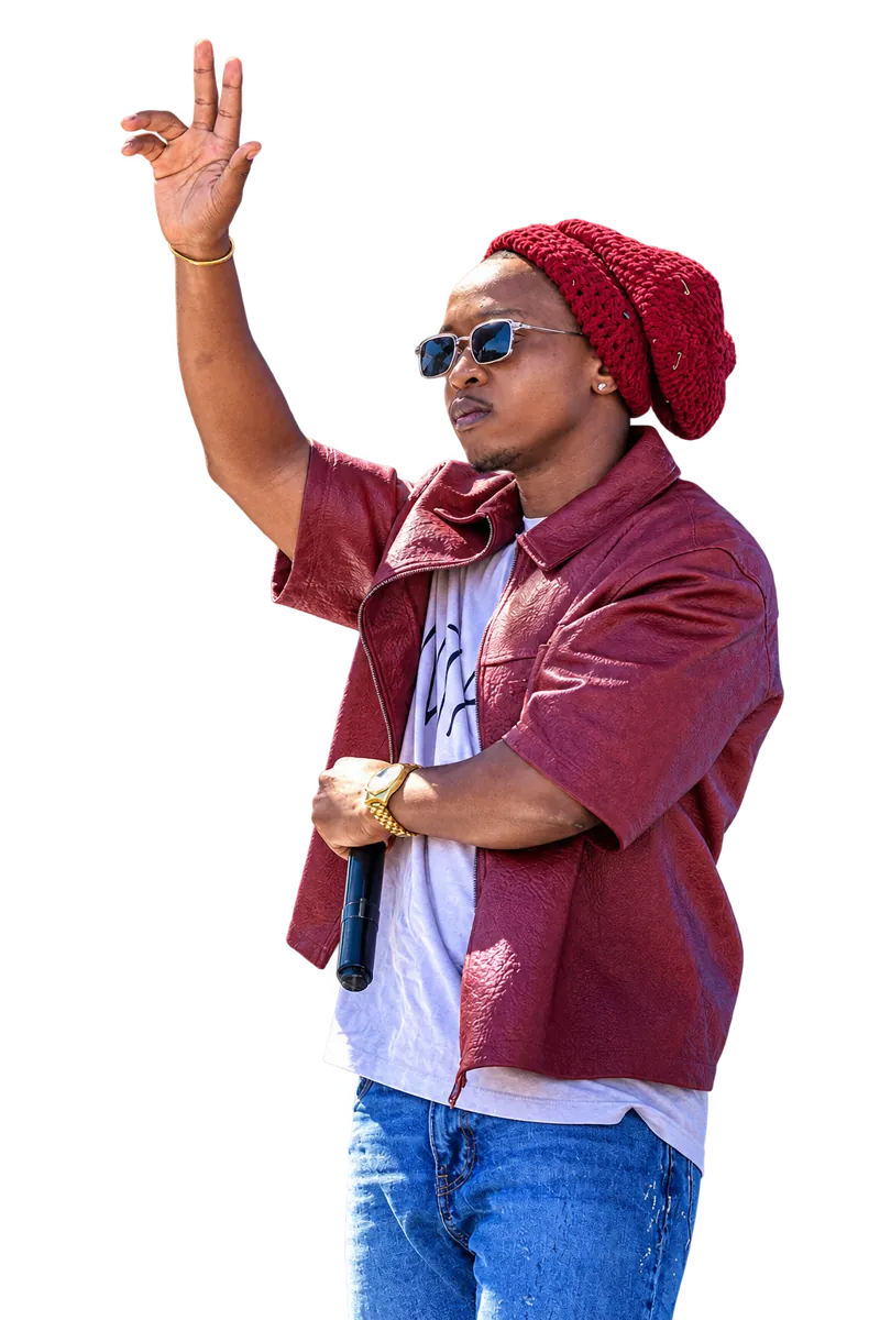 Ntate Stunna on stage in a maroon leather jacket and jeans, arm raised to the crowd